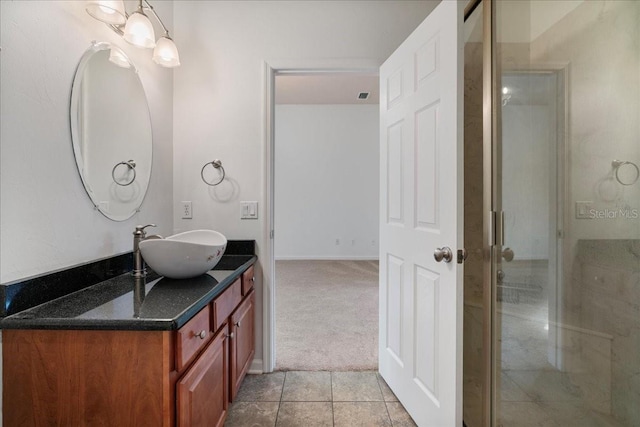 bathroom featuring tile patterned floors, vanity, and a shower with door