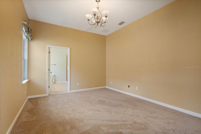 unfurnished room featuring a chandelier and carpet floors