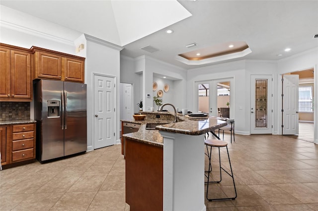 13554 NW 7th Rd, Newberry, FL 32669 - kitchen with appliances with stainless steel finishes, a breakfast bar, crown molding, brown cabinets, and a raised ceiling