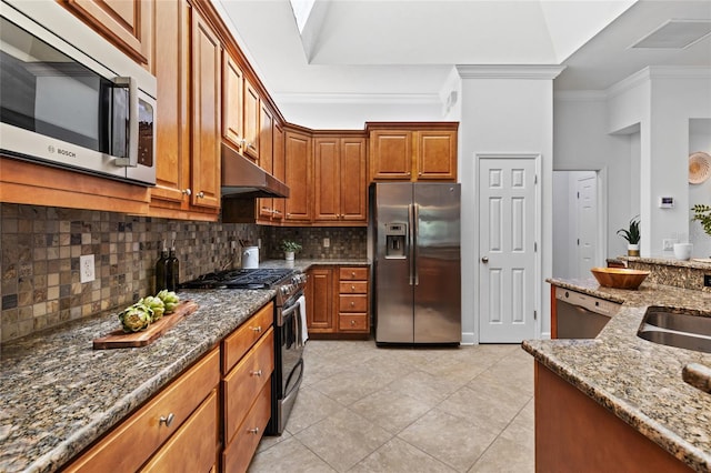 13554 NW 7th Rd, Newberry, FL 32669 - kitchen with stainless steel appliances, under cabinet range hood, tasteful backsplash, crown molding, and dark stone counters