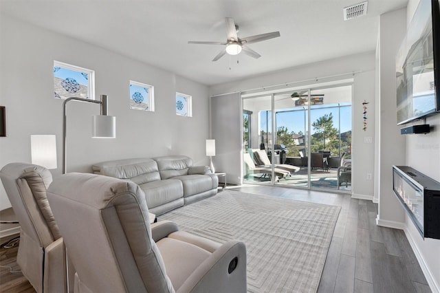 living room featuring ceiling fan and dark hardwood / wood-style flooring