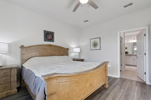 bedroom with connected bathroom, ceiling fan, and dark hardwood / wood-style flooring