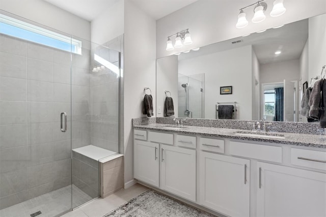 bathroom featuring tile patterned flooring, vanity, and a shower with door