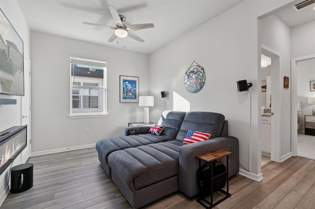 living room featuring ceiling fan and hardwood / wood-style flooring