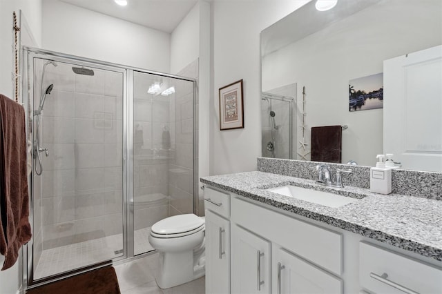 bathroom featuring tile patterned floors, vanity, toilet, and a shower with door