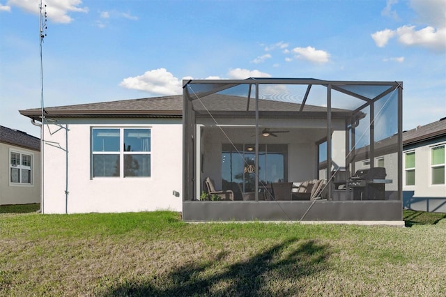 back of property featuring a patio area, ceiling fan, a lanai, and a lawn