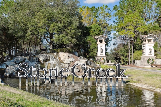 community / neighborhood sign featuring a water view