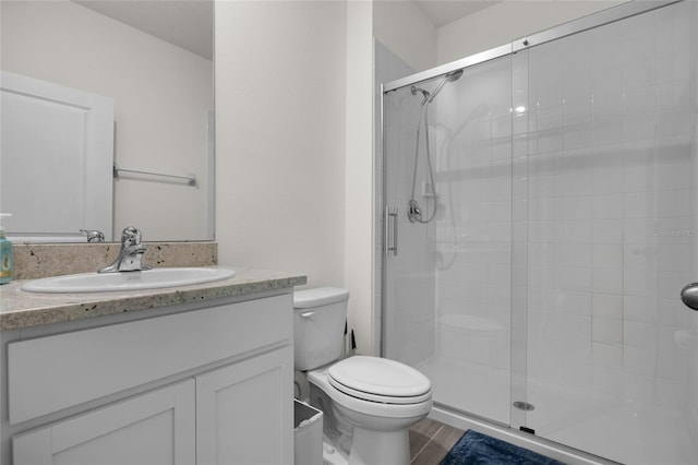 bathroom with toilet, a shower with door, wood-type flooring, and vanity