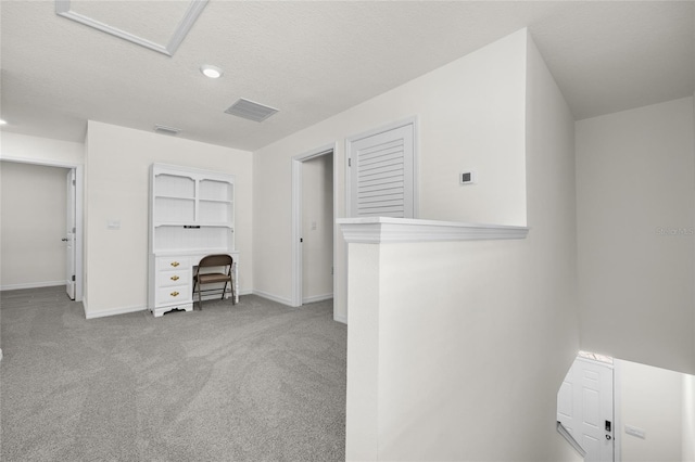 interior space featuring a textured ceiling and light colored carpet