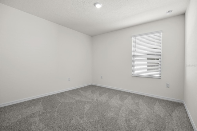 carpeted spare room featuring a textured ceiling