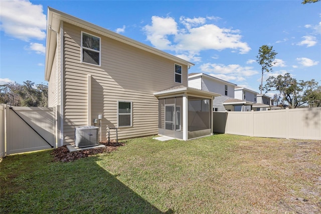 rear view of house featuring a yard, central AC, and a sunroom