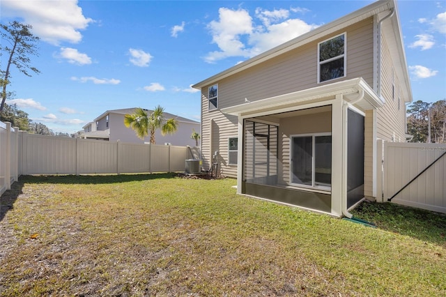 rear view of property featuring a yard, cooling unit, and a sunroom