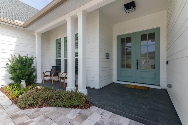 entrance to property with a porch and french doors