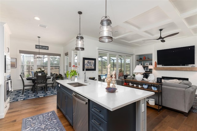 kitchen with stainless steel dishwasher, hanging light fixtures, sink, and a center island with sink