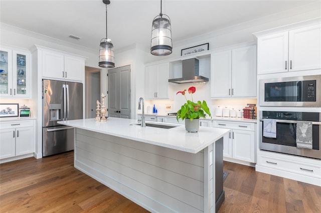 kitchen featuring pendant lighting, appliances with stainless steel finishes, wall chimney exhaust hood, and white cabinets