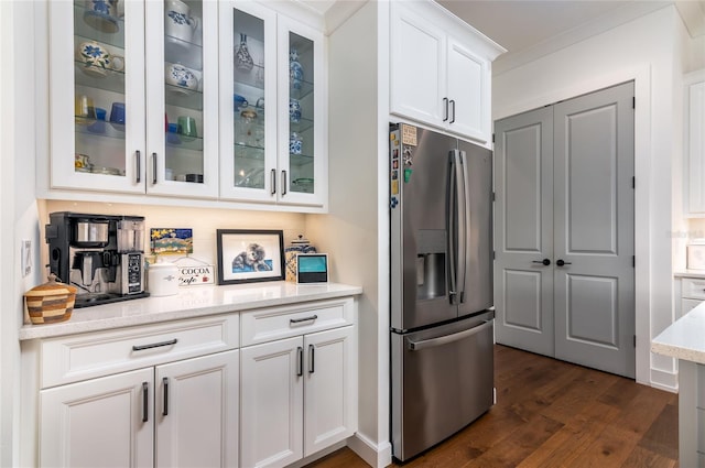 kitchen with white cabinets, dark hardwood / wood-style flooring, decorative backsplash, light stone counters, and stainless steel refrigerator with ice dispenser