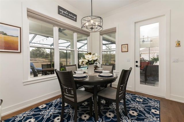 dining space featuring crown molding, dark hardwood / wood-style floors, and a notable chandelier