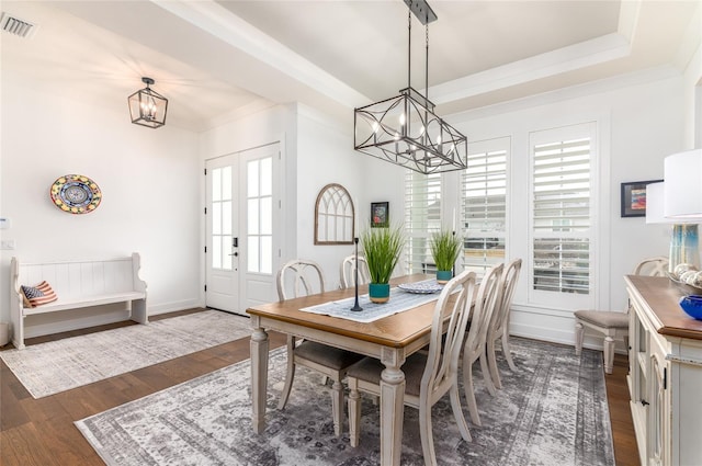 dining space with an inviting chandelier, ornamental molding, and dark hardwood / wood-style floors