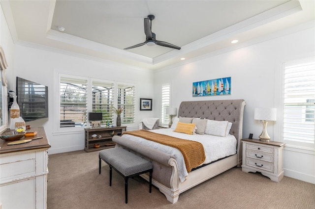 bedroom with multiple windows, crown molding, light carpet, and a raised ceiling