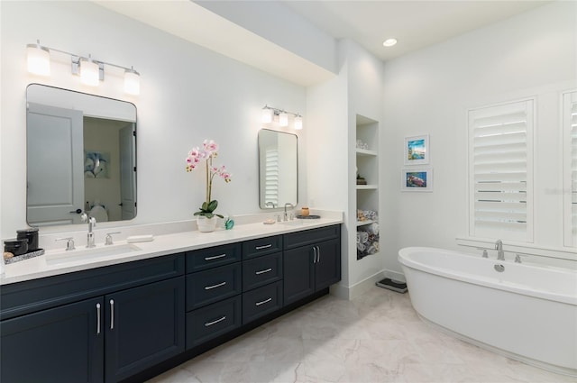 bathroom with vanity, built in shelves, and a bathing tub