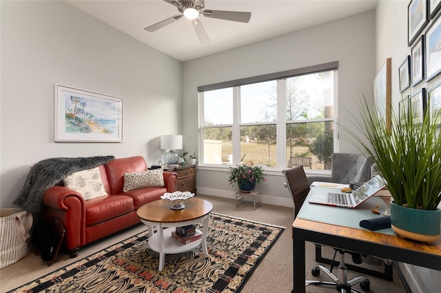 carpeted home office featuring ceiling fan