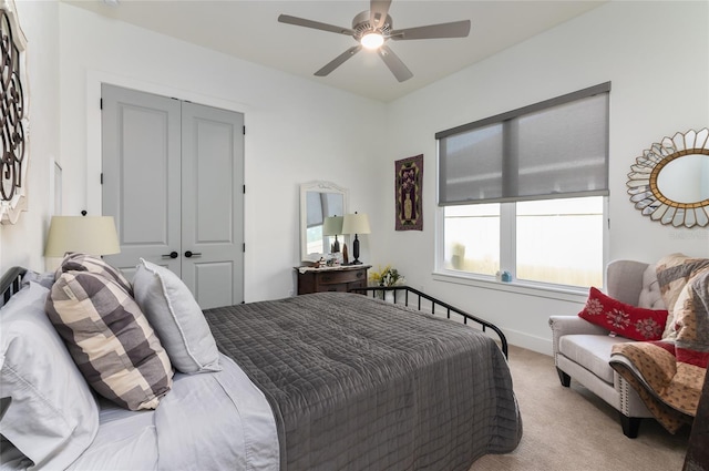 carpeted bedroom featuring ceiling fan and a closet