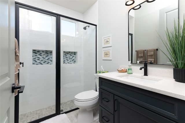 bathroom featuring an enclosed shower, vanity, and toilet