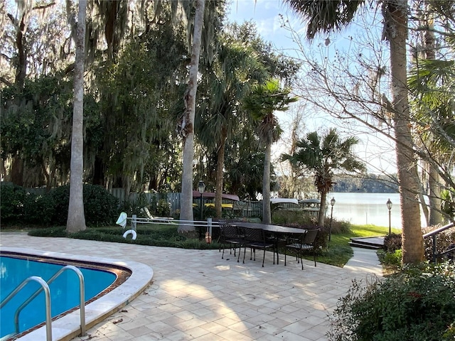 view of pool with a patio area and a water view