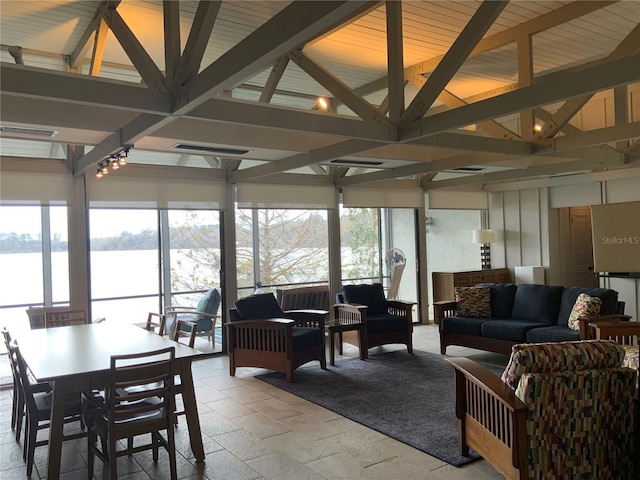 sunroom / solarium featuring a water view and beamed ceiling