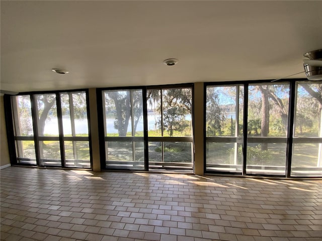 unfurnished sunroom with a water view and a healthy amount of sunlight