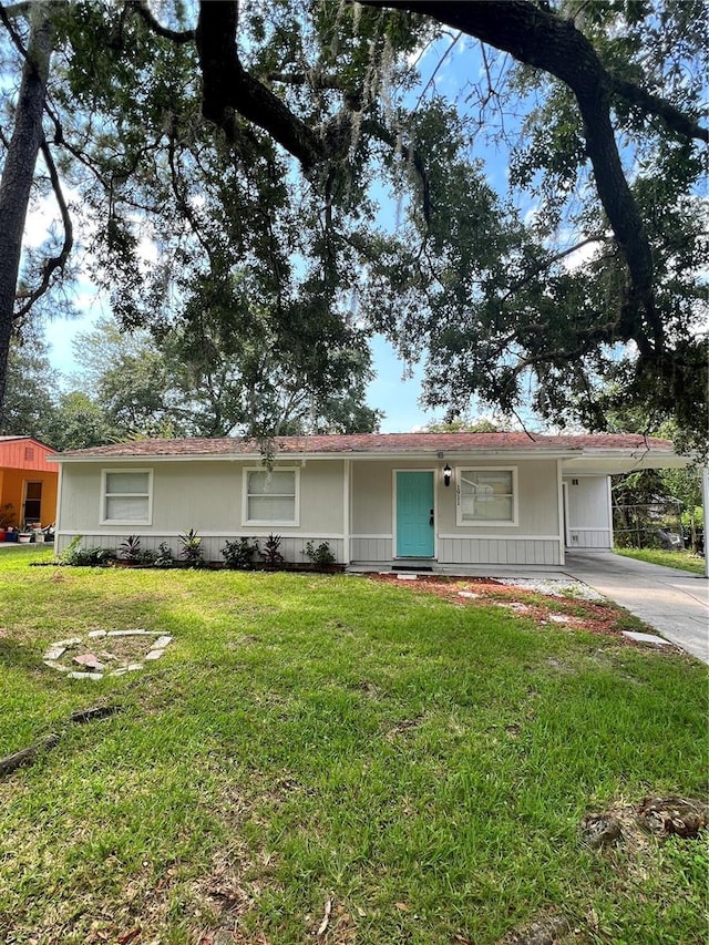 ranch-style home with a carport and a front lawn