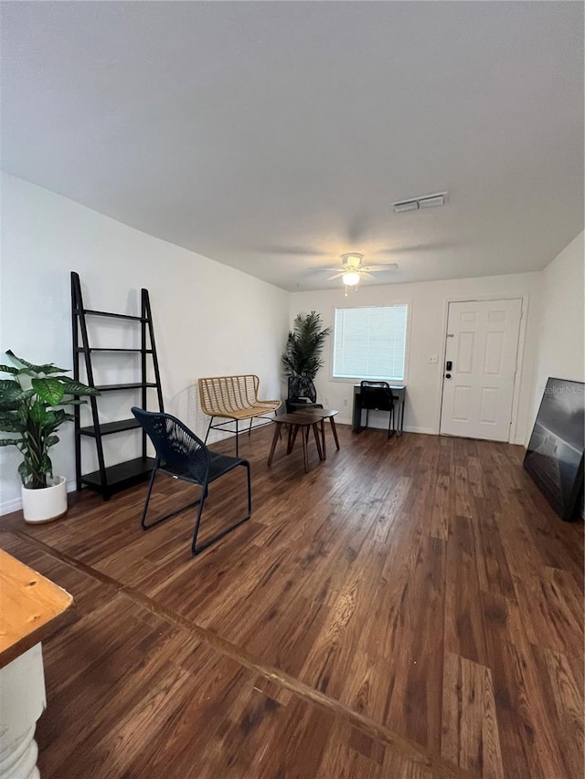 living area with dark hardwood / wood-style flooring and ceiling fan