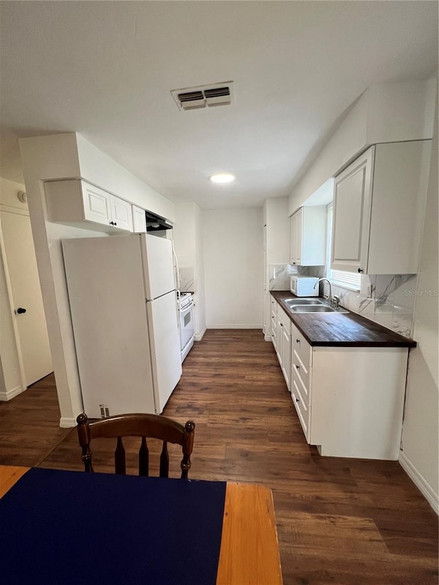 kitchen with dark hardwood / wood-style flooring, white cabinetry, sink, and white appliances