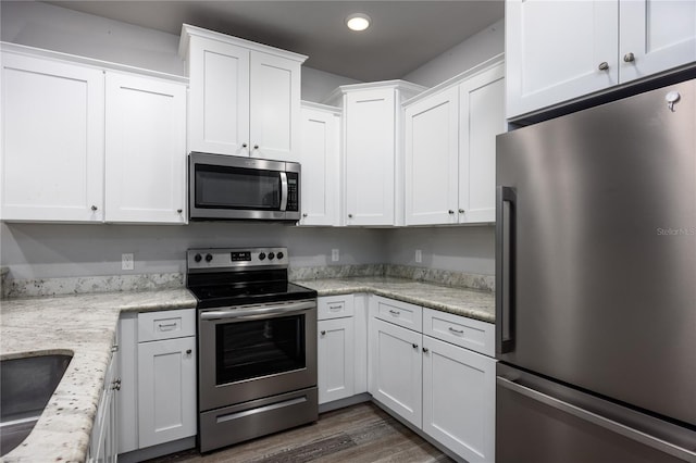 kitchen featuring dark wood-type flooring, white cabinets, sink, light stone countertops, and stainless steel appliances