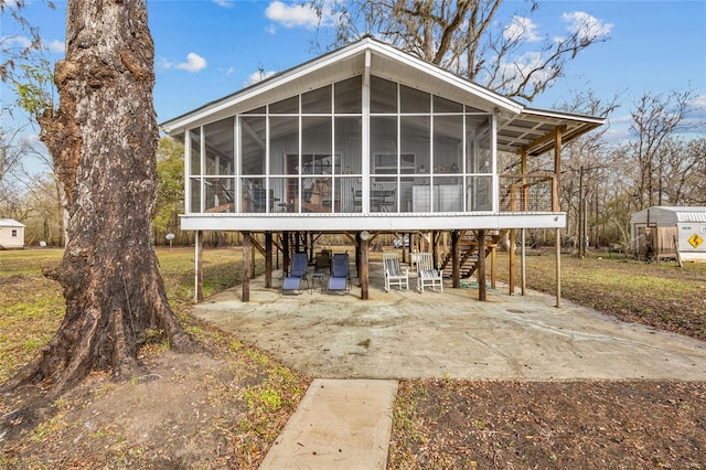 rear view of house featuring a patio area and a sunroom