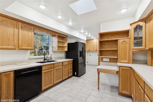 kitchen featuring sink, a skylight, and black appliances