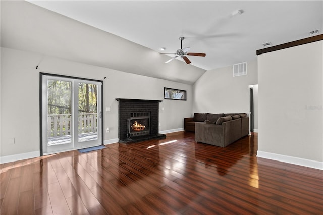 unfurnished living room featuring ceiling fan, dark hardwood / wood-style flooring, vaulted ceiling, and a brick fireplace