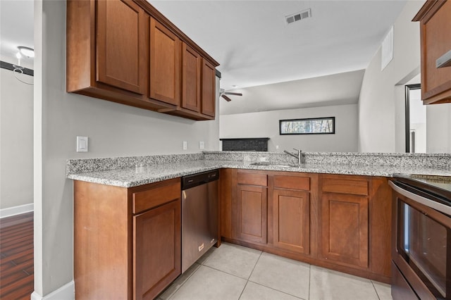 kitchen featuring light stone counters, brown cabinets, visible vents, stainless steel dishwasher, and a peninsula