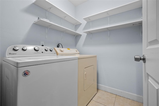 washroom with laundry area, independent washer and dryer, baseboards, and light tile patterned floors