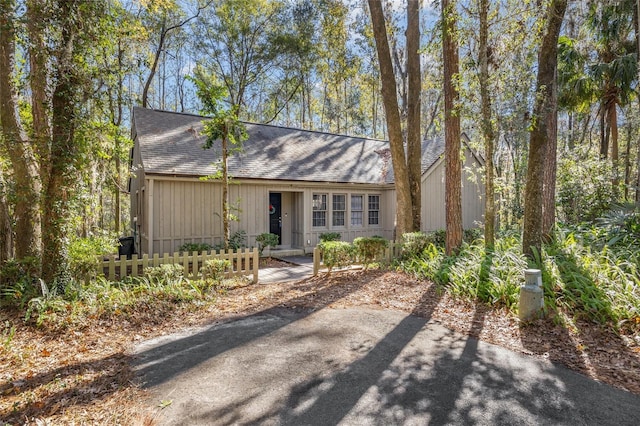 view of front of property with a shingled roof and a fenced front yard