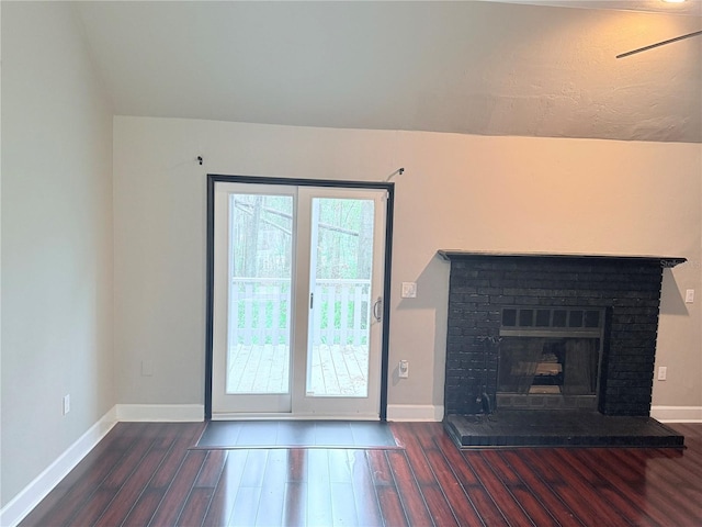 unfurnished living room with a brick fireplace, baseboards, and dark wood finished floors