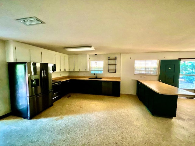 kitchen with a textured ceiling, black appliances, sink, white cabinets, and hanging light fixtures