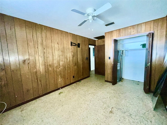 unfurnished bedroom featuring wooden walls, a closet, and ceiling fan