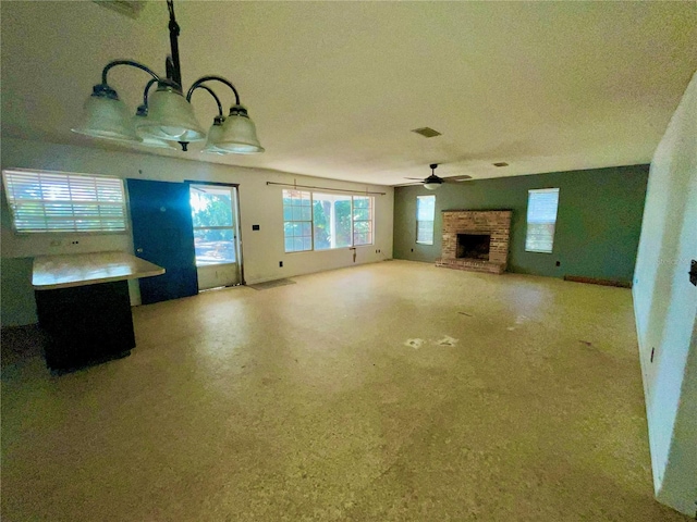 unfurnished living room with a fireplace and ceiling fan