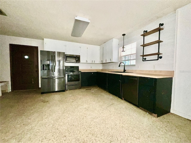 kitchen featuring white cabinets, decorative light fixtures, sink, and appliances with stainless steel finishes