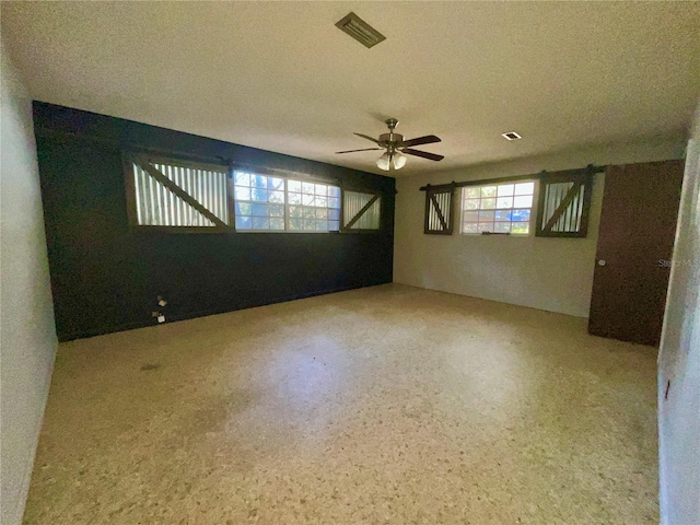 spare room with ceiling fan and a textured ceiling