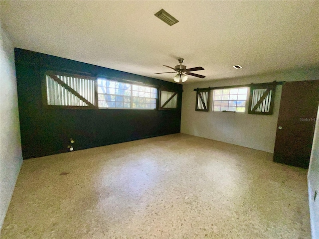 empty room with a textured ceiling and ceiling fan