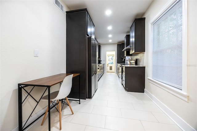 kitchen with backsplash, light stone counters, and stainless steel range with electric cooktop