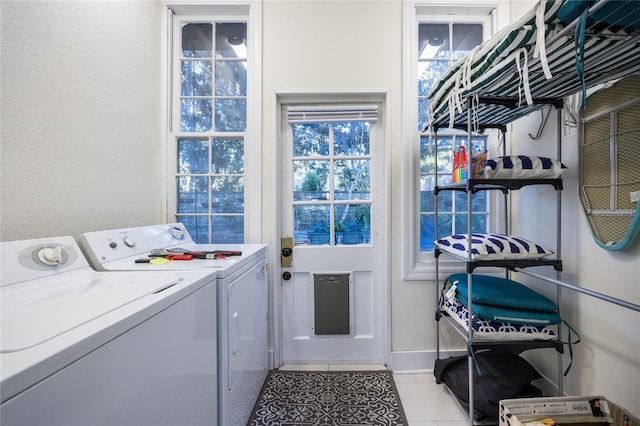 clothes washing area featuring light tile patterned floors and washing machine and dryer