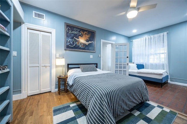 bedroom with ceiling fan, wood-type flooring, and a closet